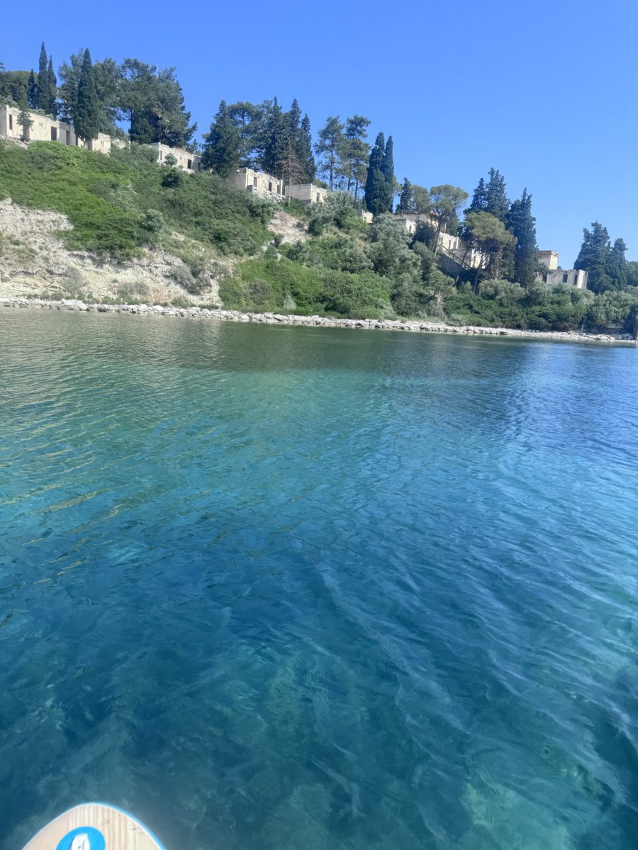 Terk edilmiş tatil köyü kayalık üzerinde, turkuaz su