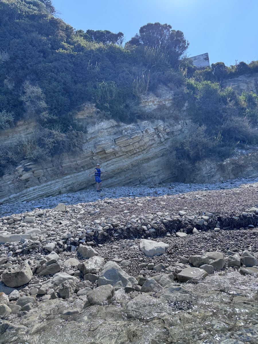 Çocuk kayalık altında vahşi plajda